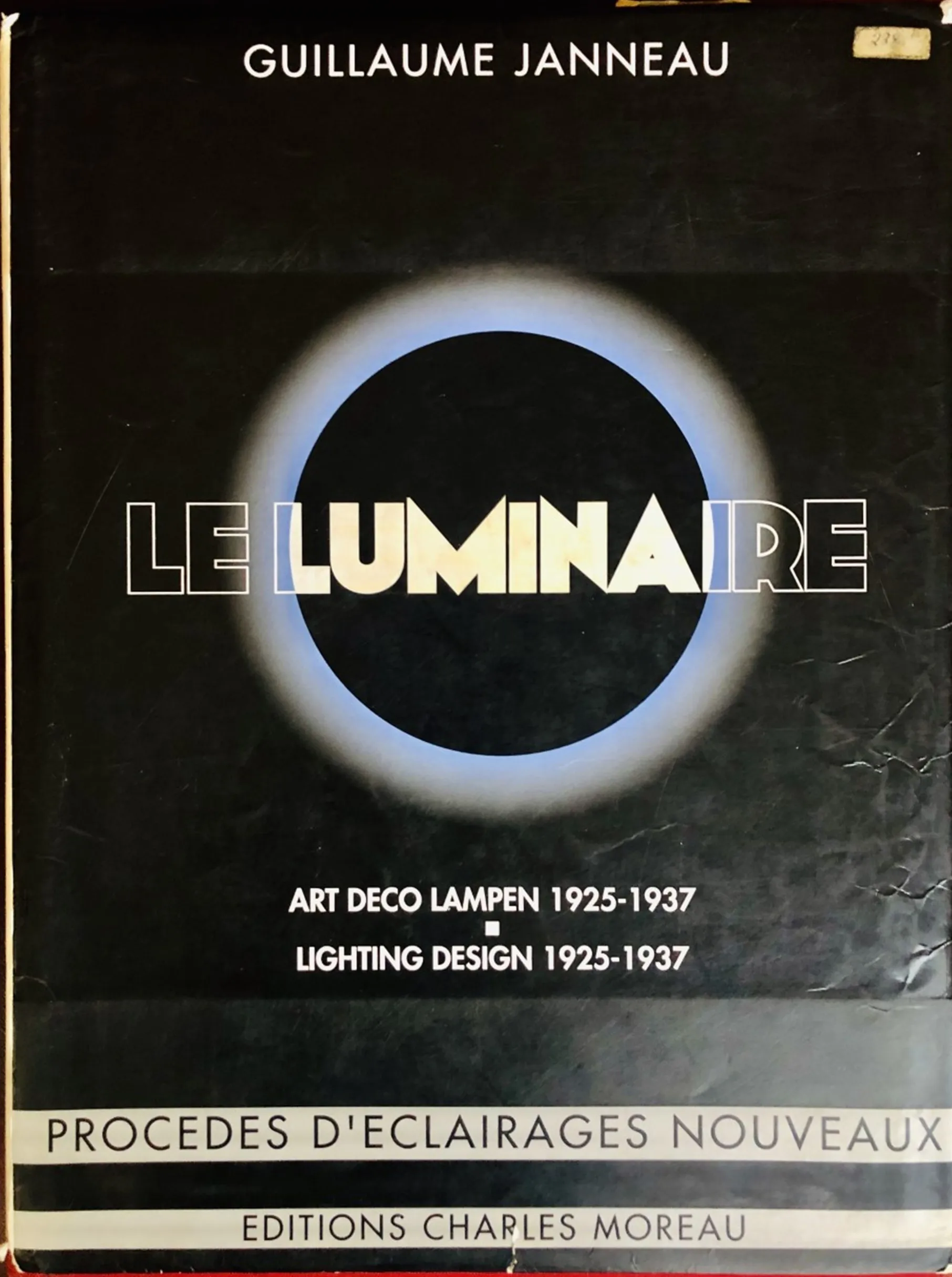 Cover of the antique book Le Luminaire featuring a simple modern design with a blue and white circle.