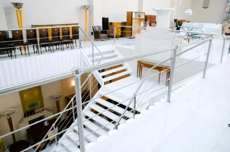 Vista del interior de Luxury Design Store mostrando antigüedades Balcarce 1084, muebles y escaleras blancas.