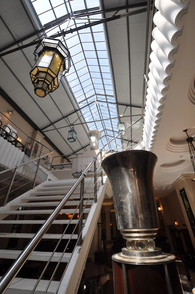Vista interior del local Luxury Design Store con escaleras y lámparas.
