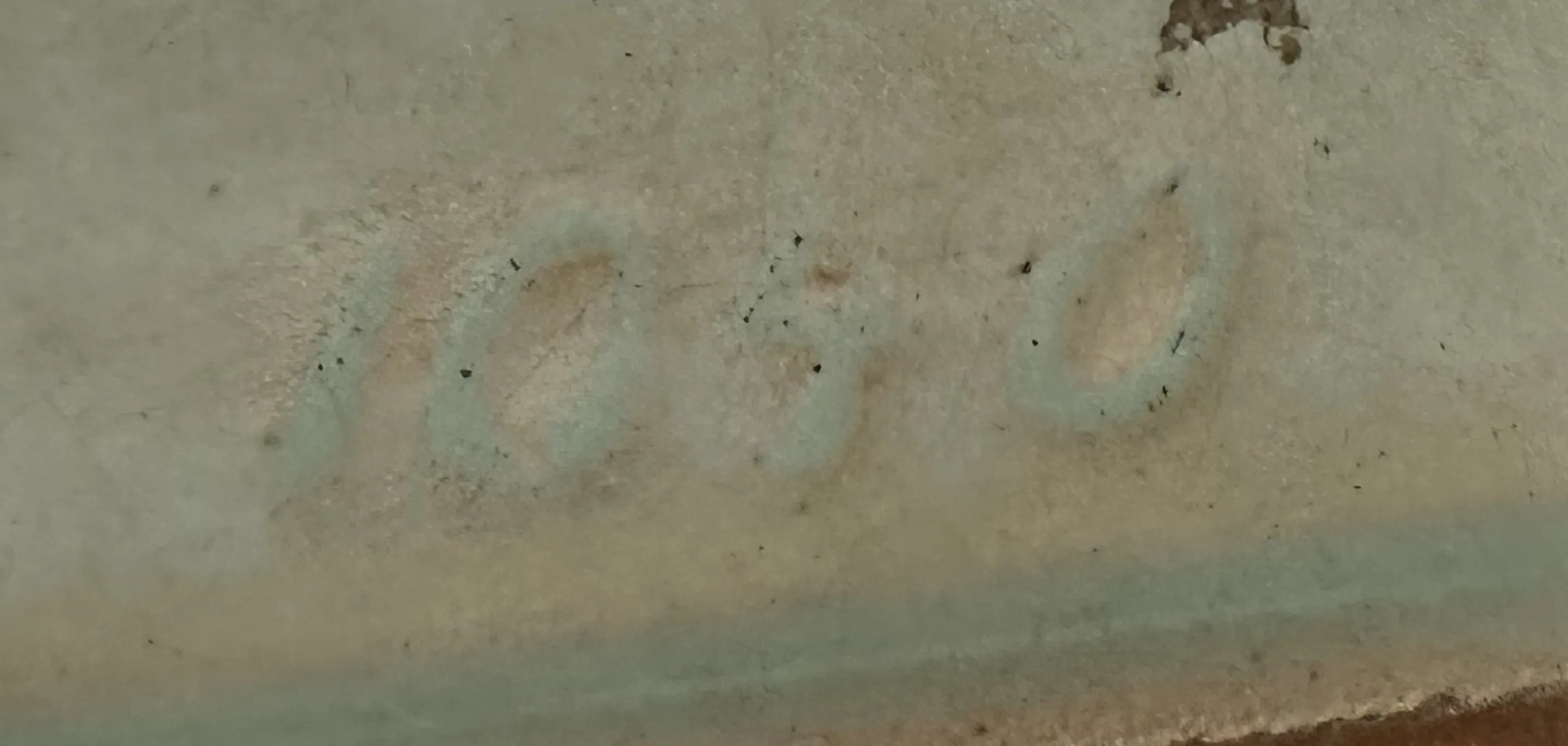 inscription of number 1050 on an antique surface