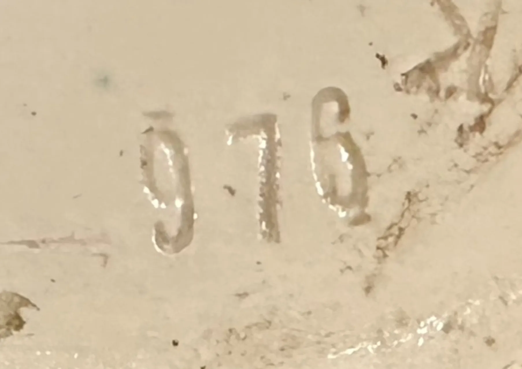 inscripción en relieve con el número 976 sobre fondo claro