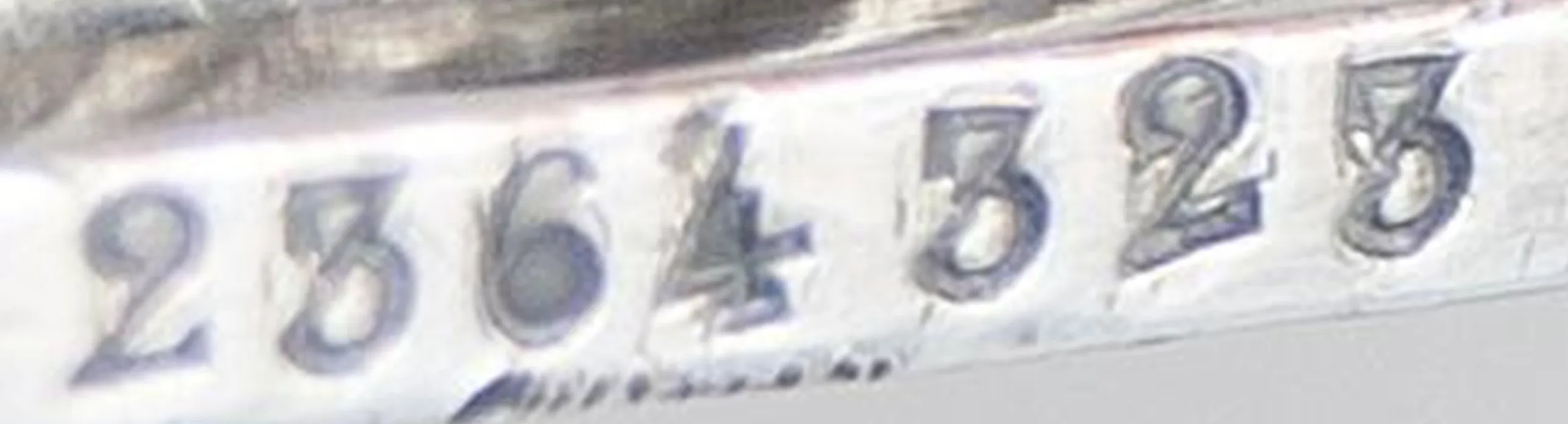 Visible serial number on an antique item.