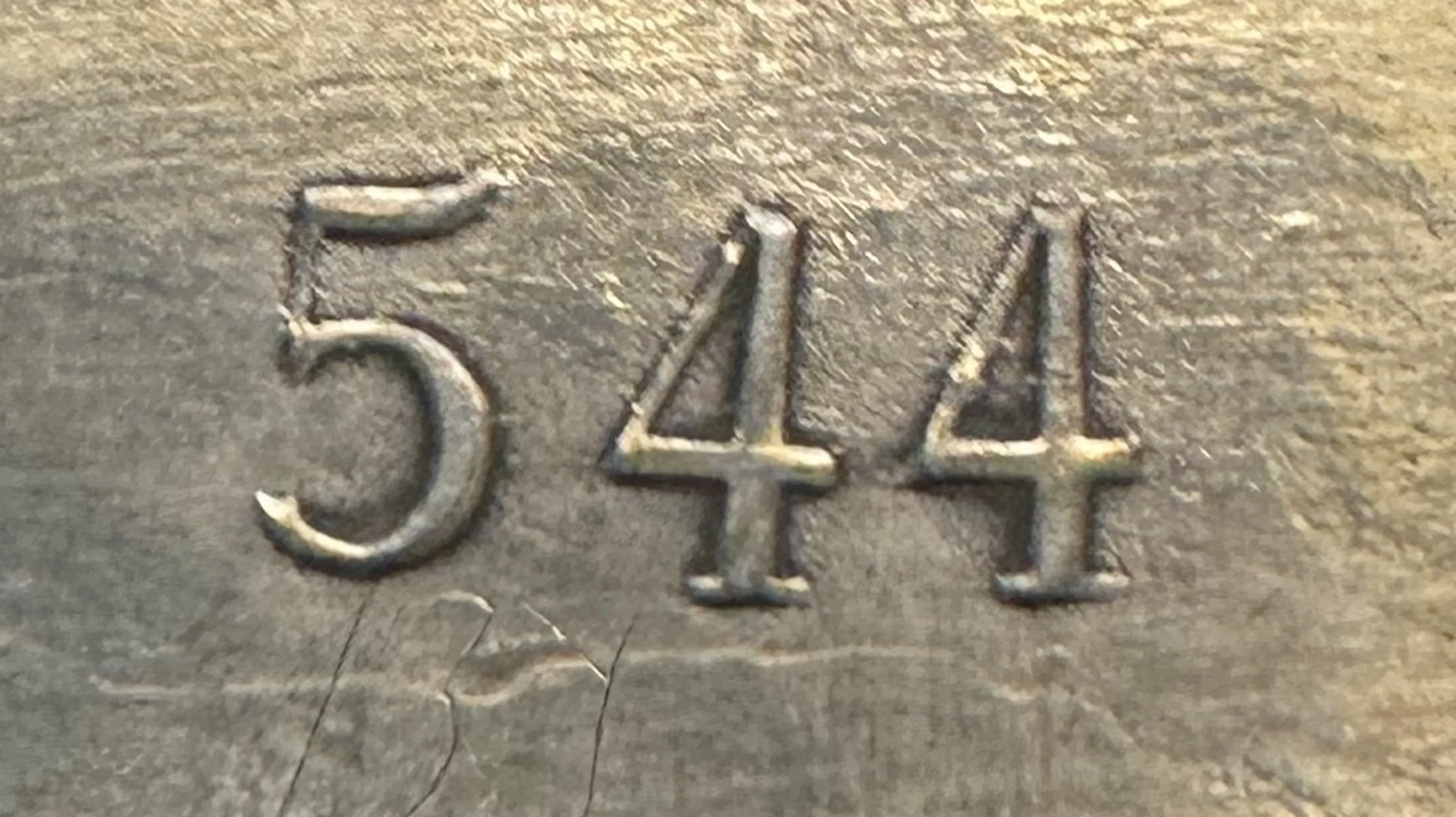 detail of antique with serial number 544 engraved