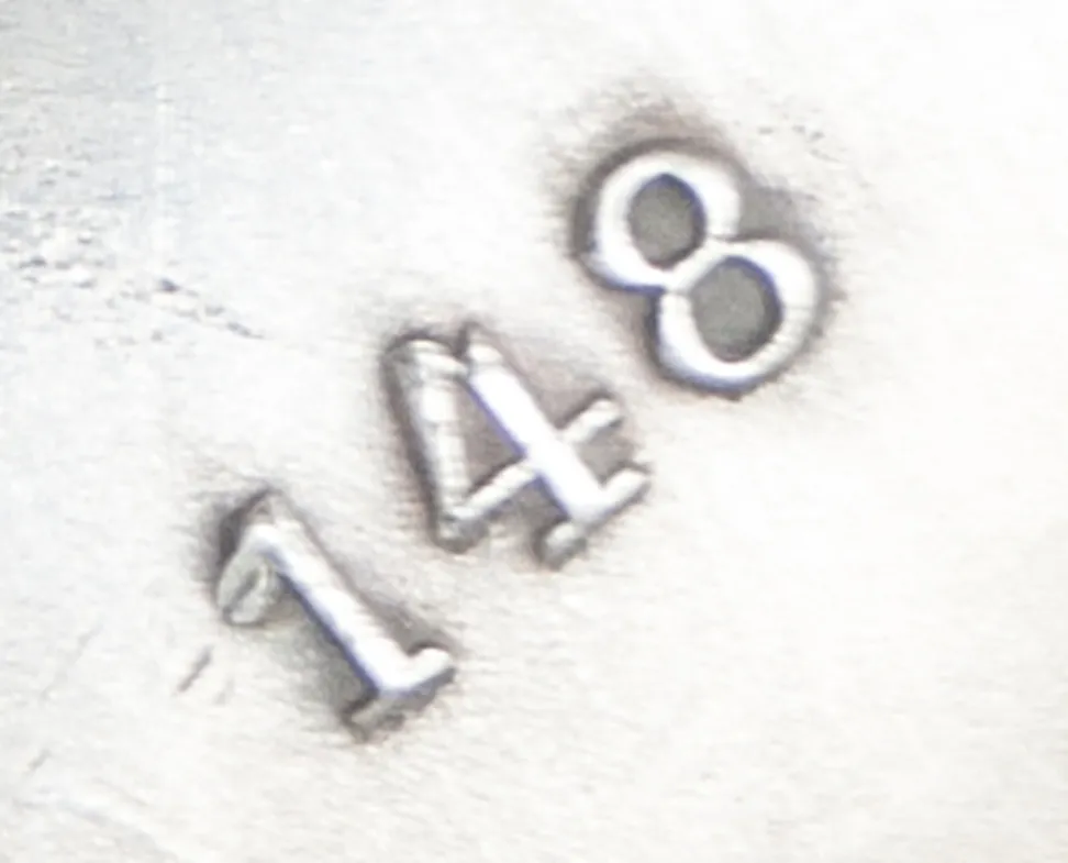 detail of a serial number engraved in metal, 148