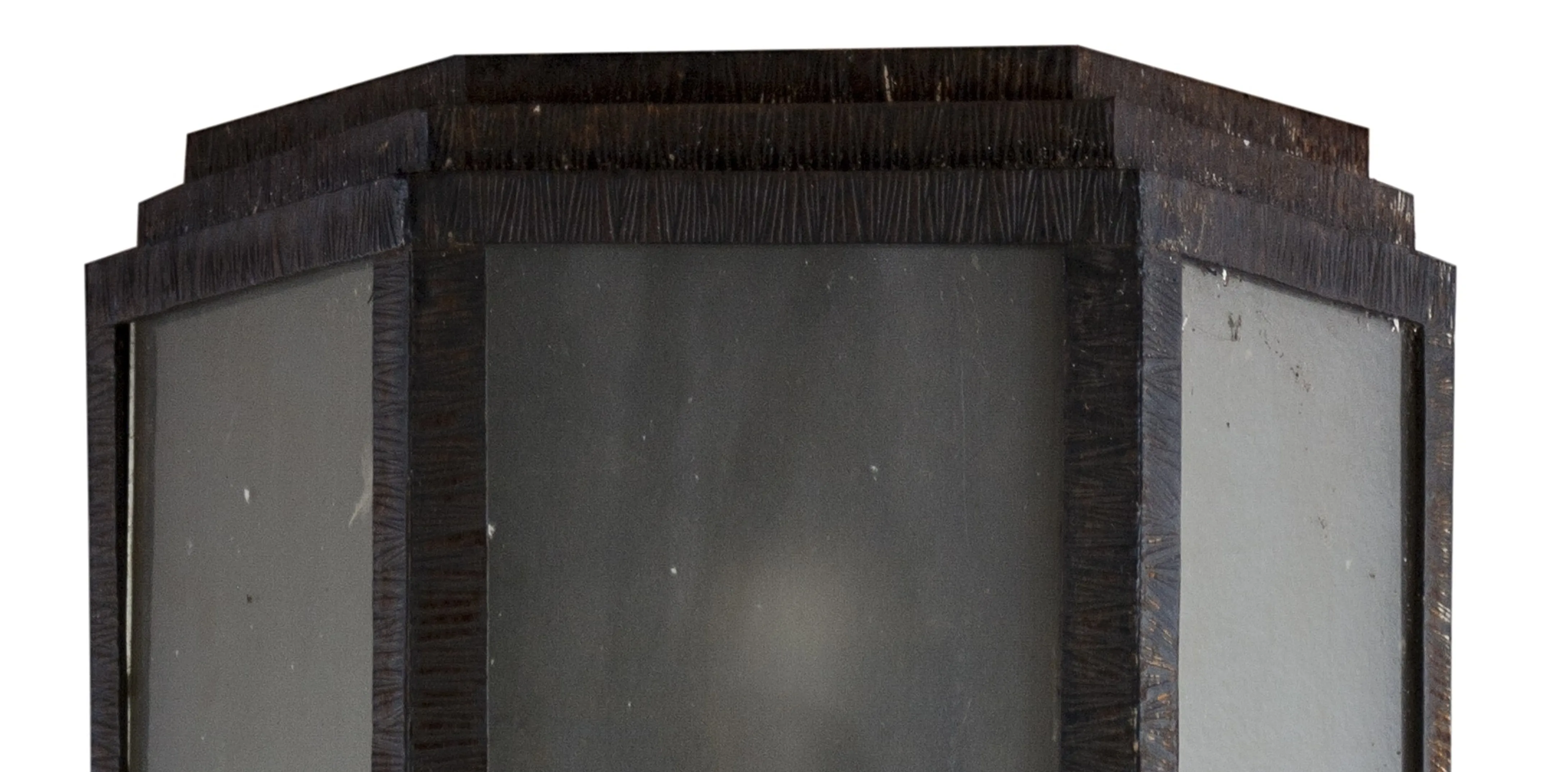 detail of an antique pair of sconces with geometric shapes and dark finishes in a decorative setting.