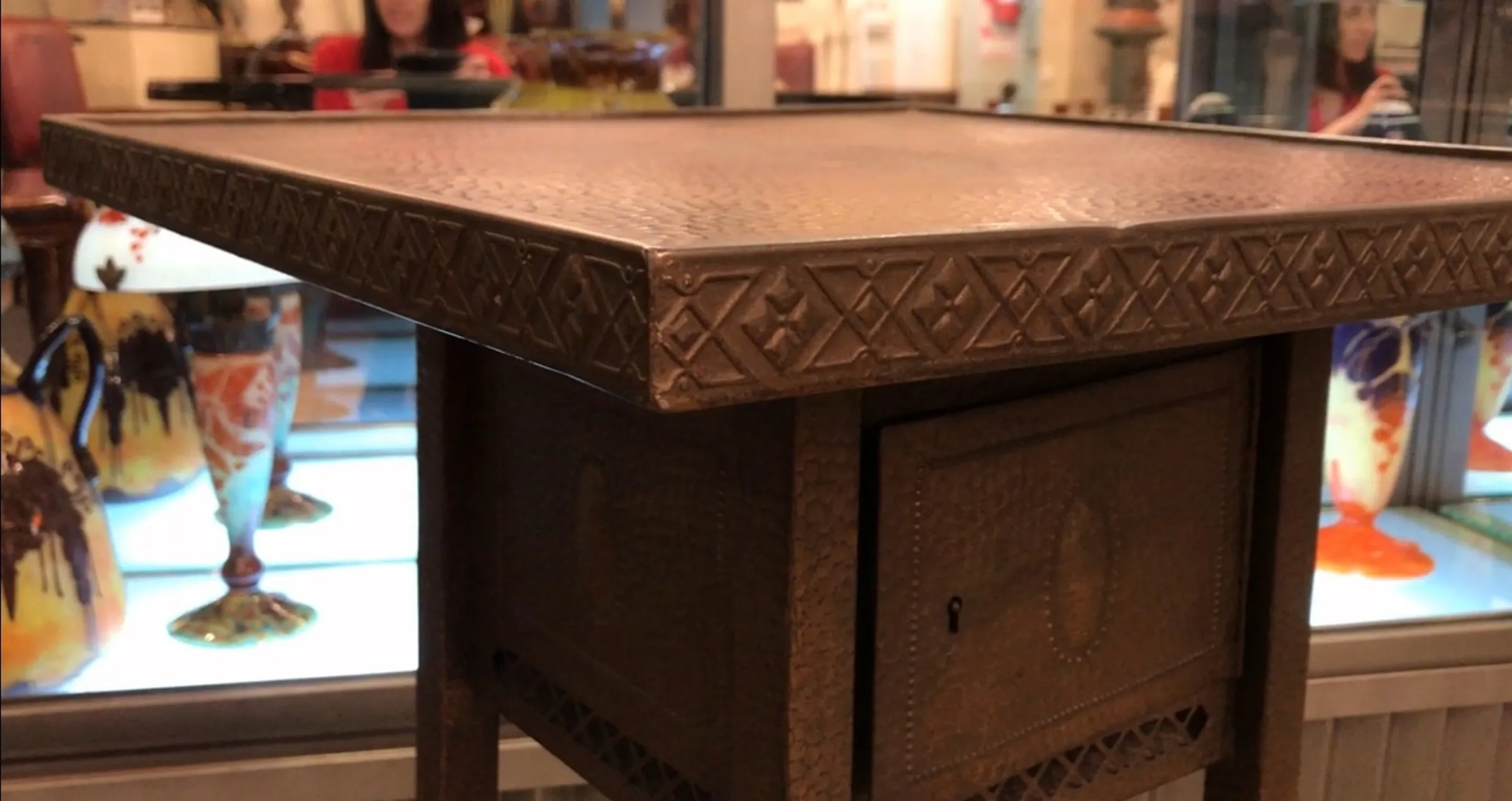 Antique small table with intricate design, cozy setting.