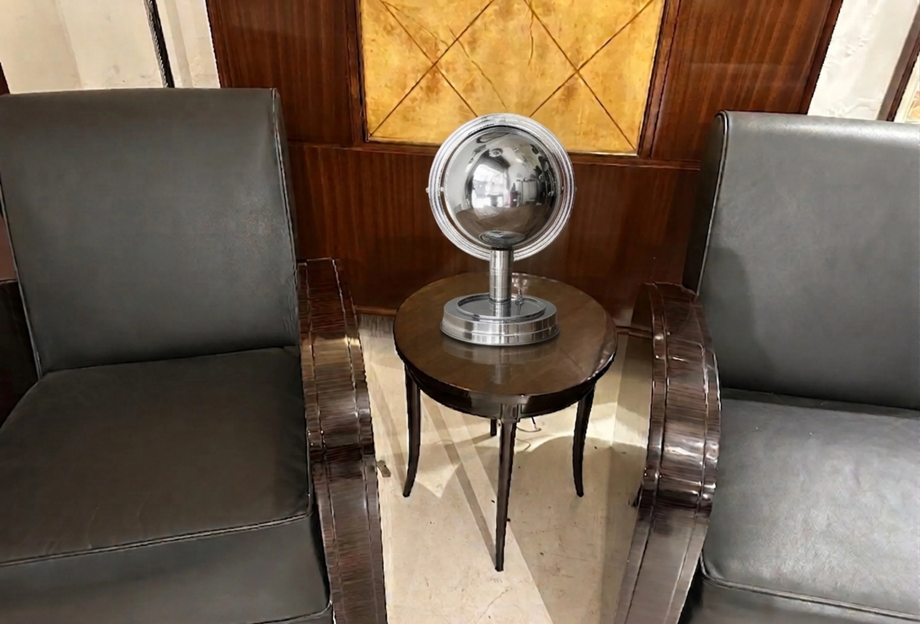 luminária de mesa antiga com base brilhante e esférica em um ambiente elegante.