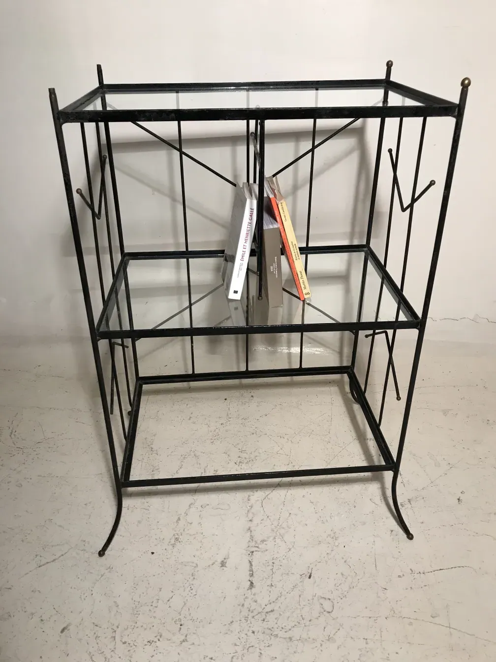 Antique metal bookcase with books on shelves