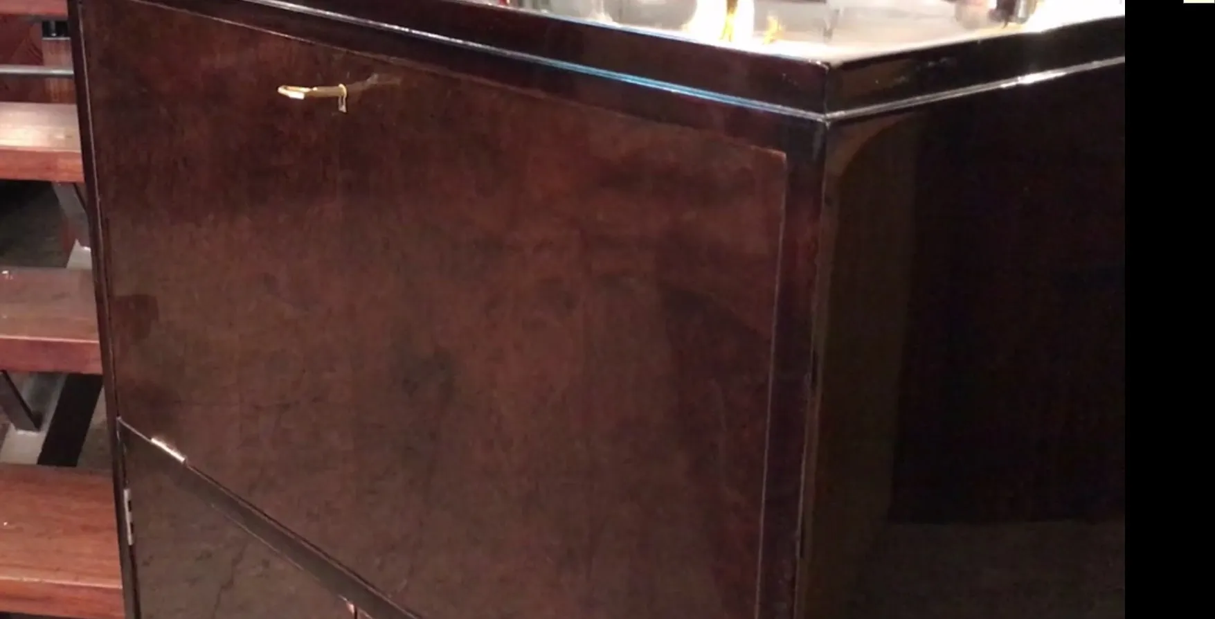 Antique wooden bar cabinet with a shiny finish in a bar setting.