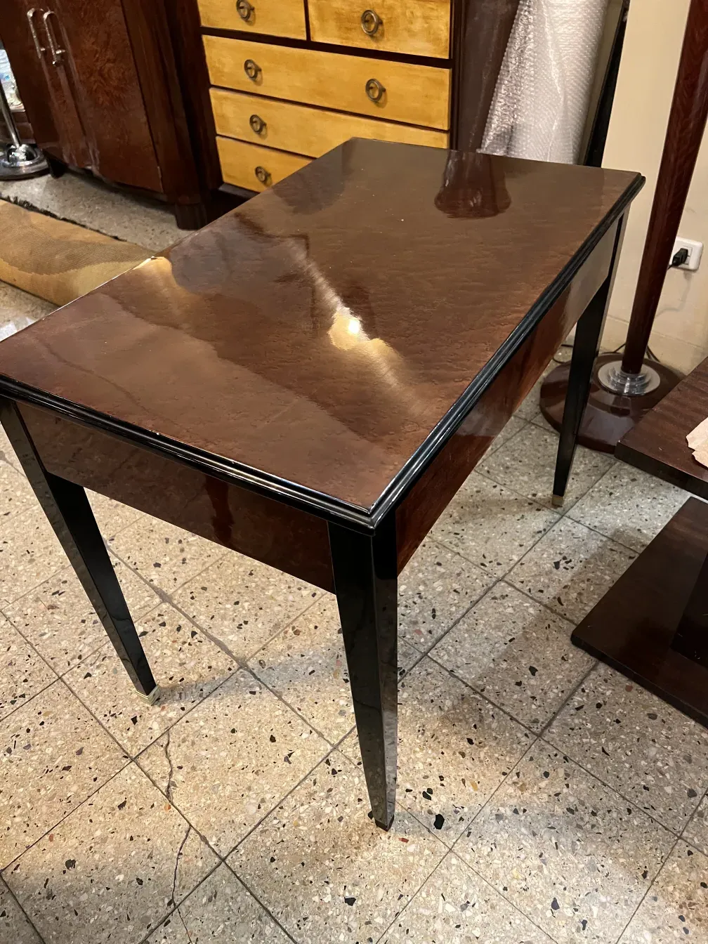 antique desk with a shiny surface and black legs, cozy atmosphere