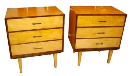 Antique bedside tables with three drawers in a cozy setting.