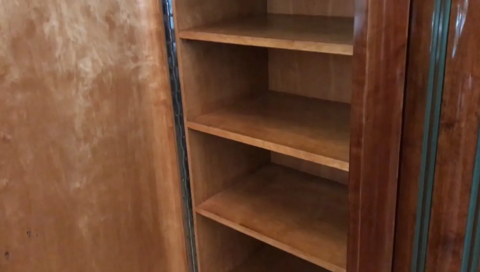 Antique bookcase with empty shelves in a classic setting.