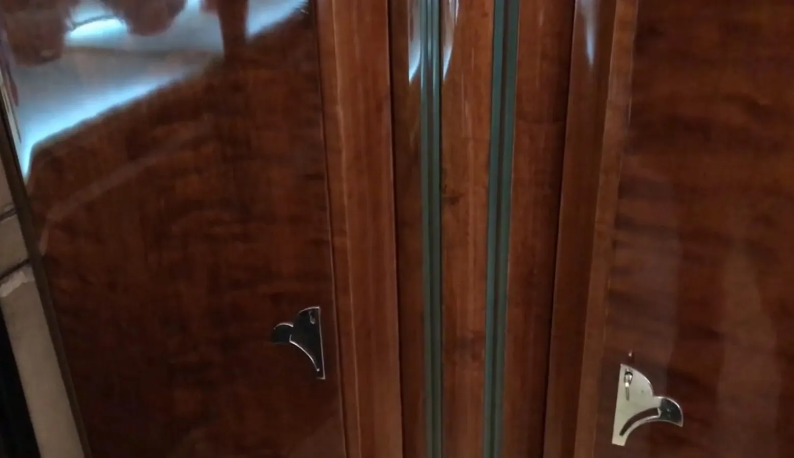 Antique bookcase featuring doors and polished wood details.