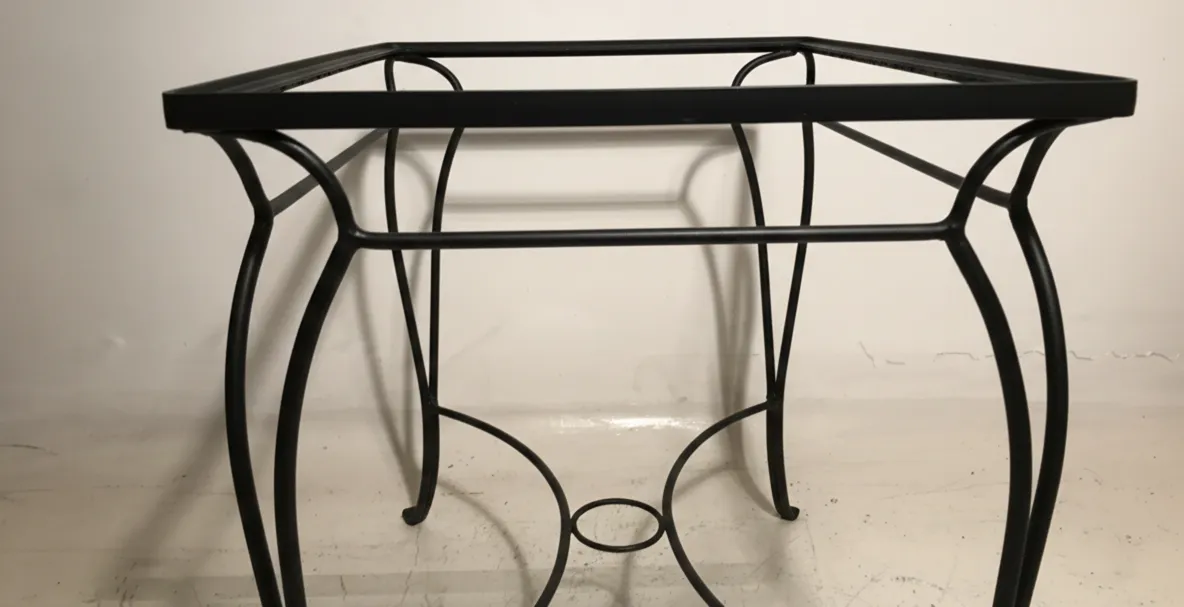 Antique table with a simple design, perfect for gardens. Context of outdoor furniture.