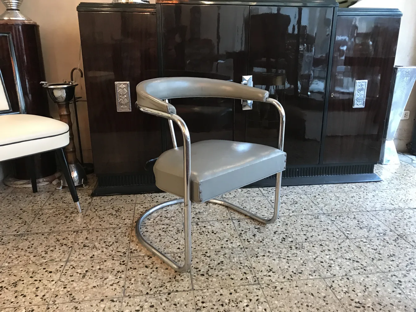 Due poltrone antiche in attesa di restauro in un ambiente di antiquariato.