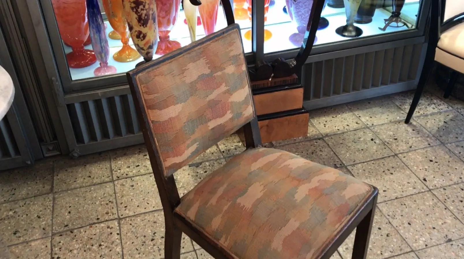 古董椅子，色彩丰富的 upholstery，背景是装饰艺术环境。