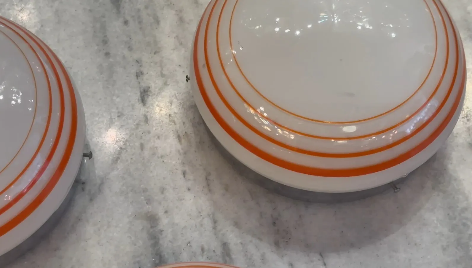 three antique ceiling lights with orange details on a light surface