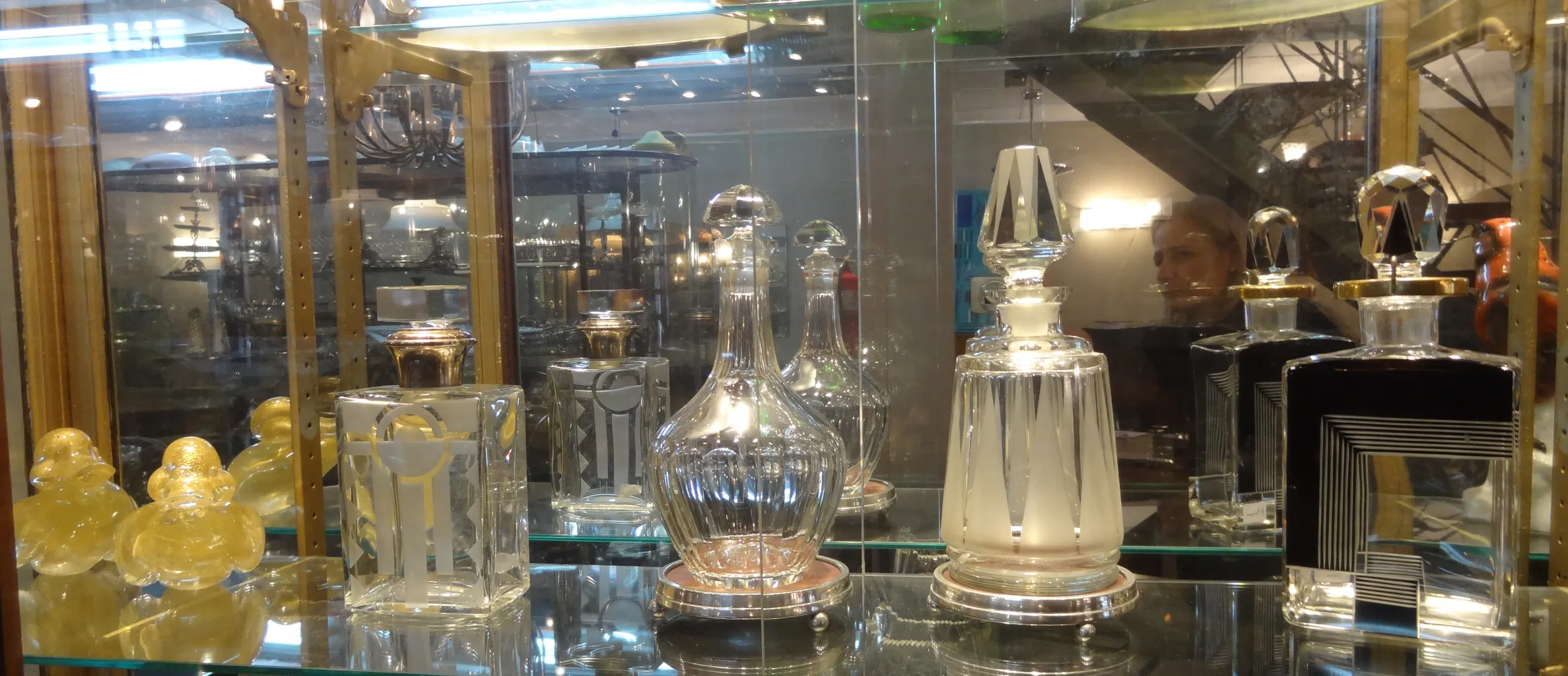 Antique bottle with elegant design and decorative details, in a showcase with other antiques.