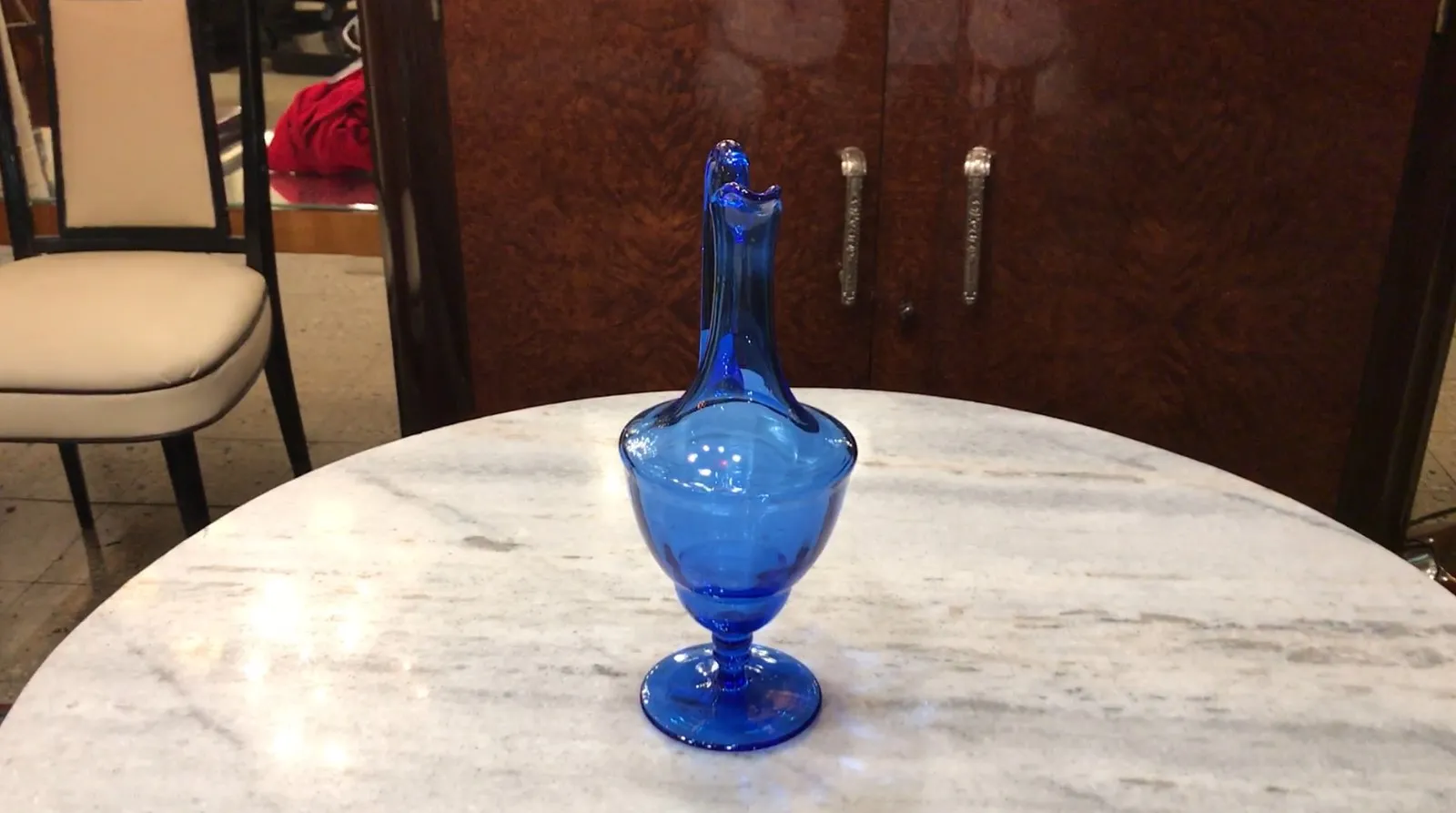 pichet ancien en verre bleu sur marbre, avec fond de meubles
