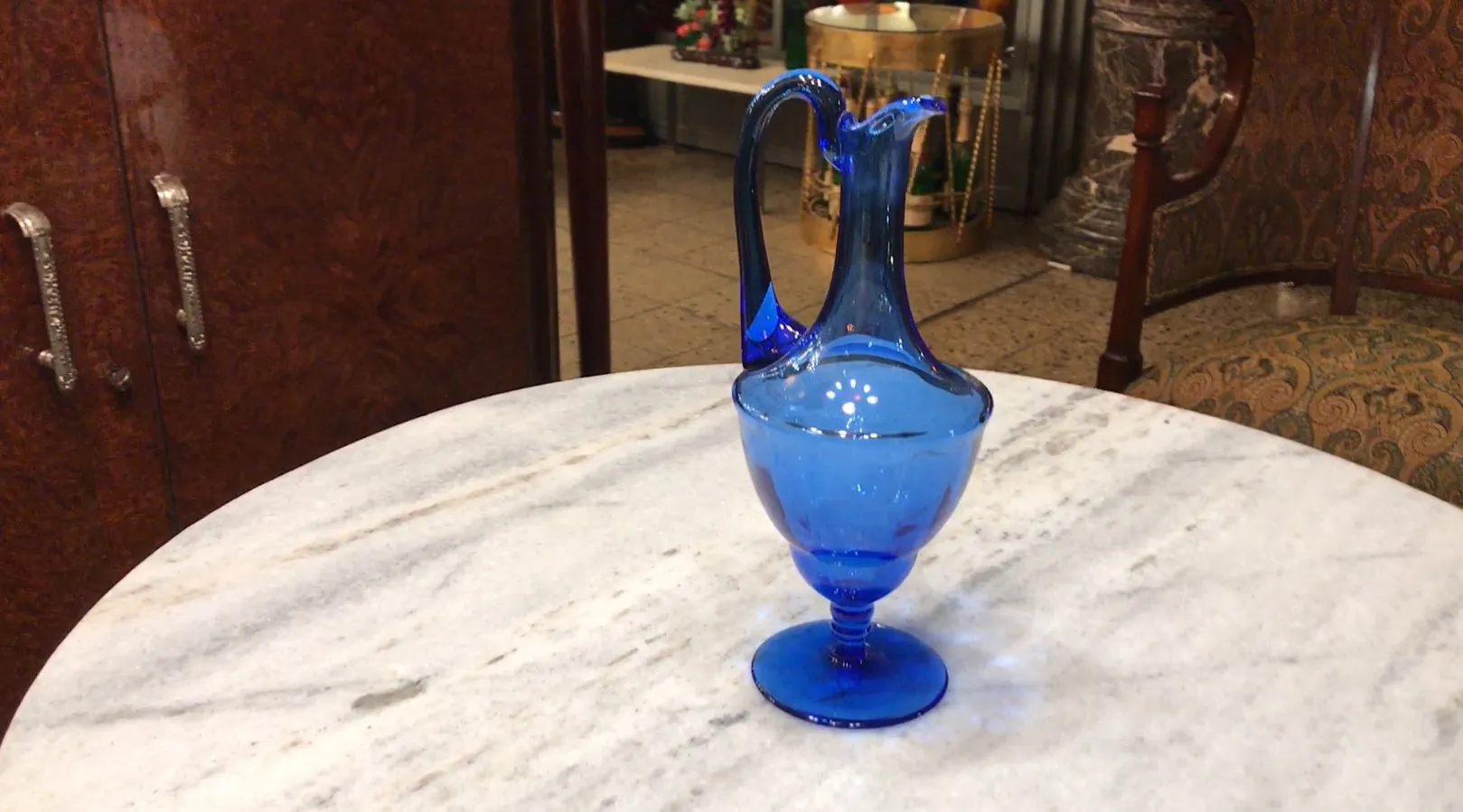 pichet ancien en verre bleu sur une table en marbre