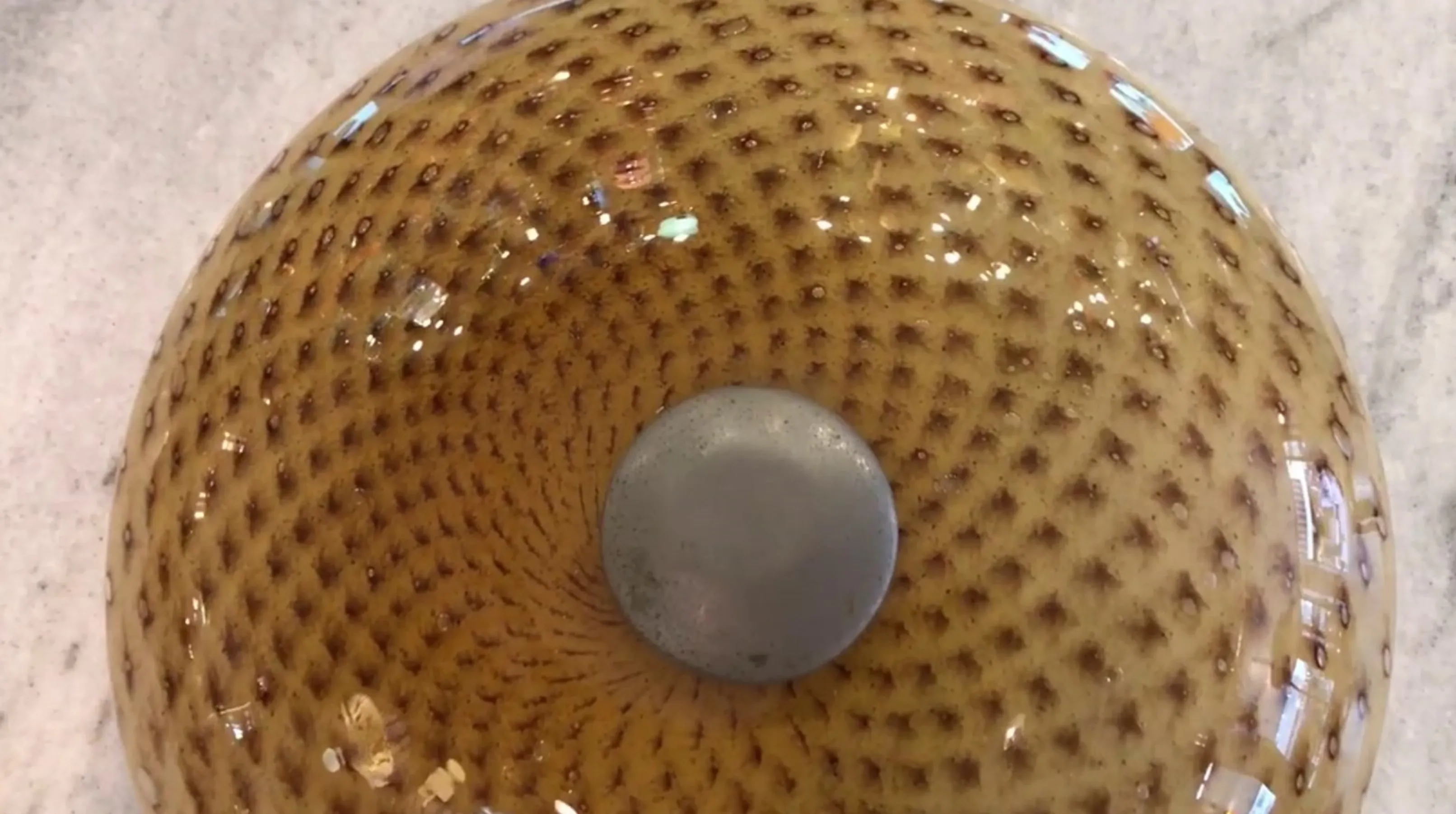 antique ceiling light with net-like patterns and a metal center