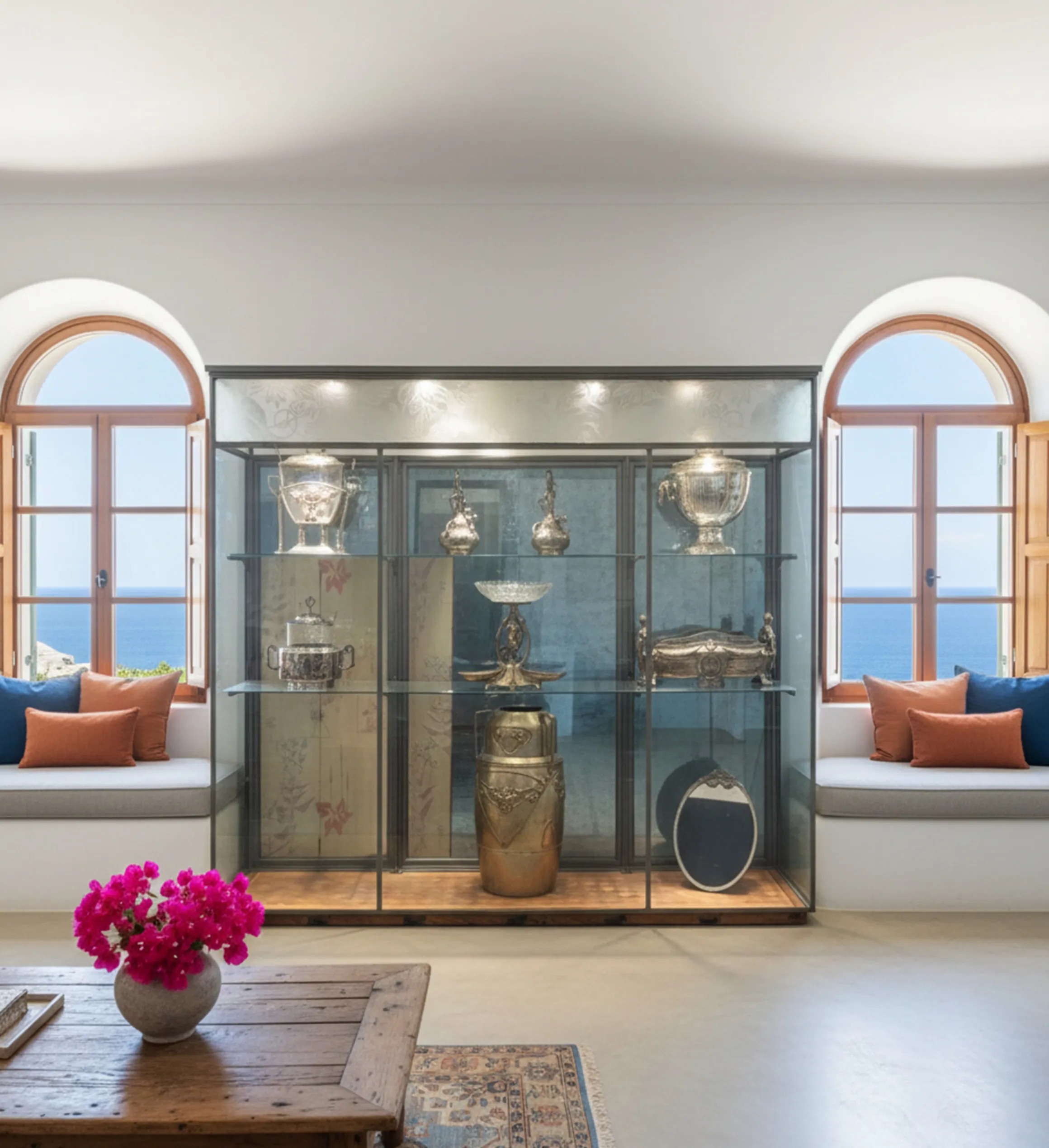 Antique display cabinet showcasing decorative items in a bright room.