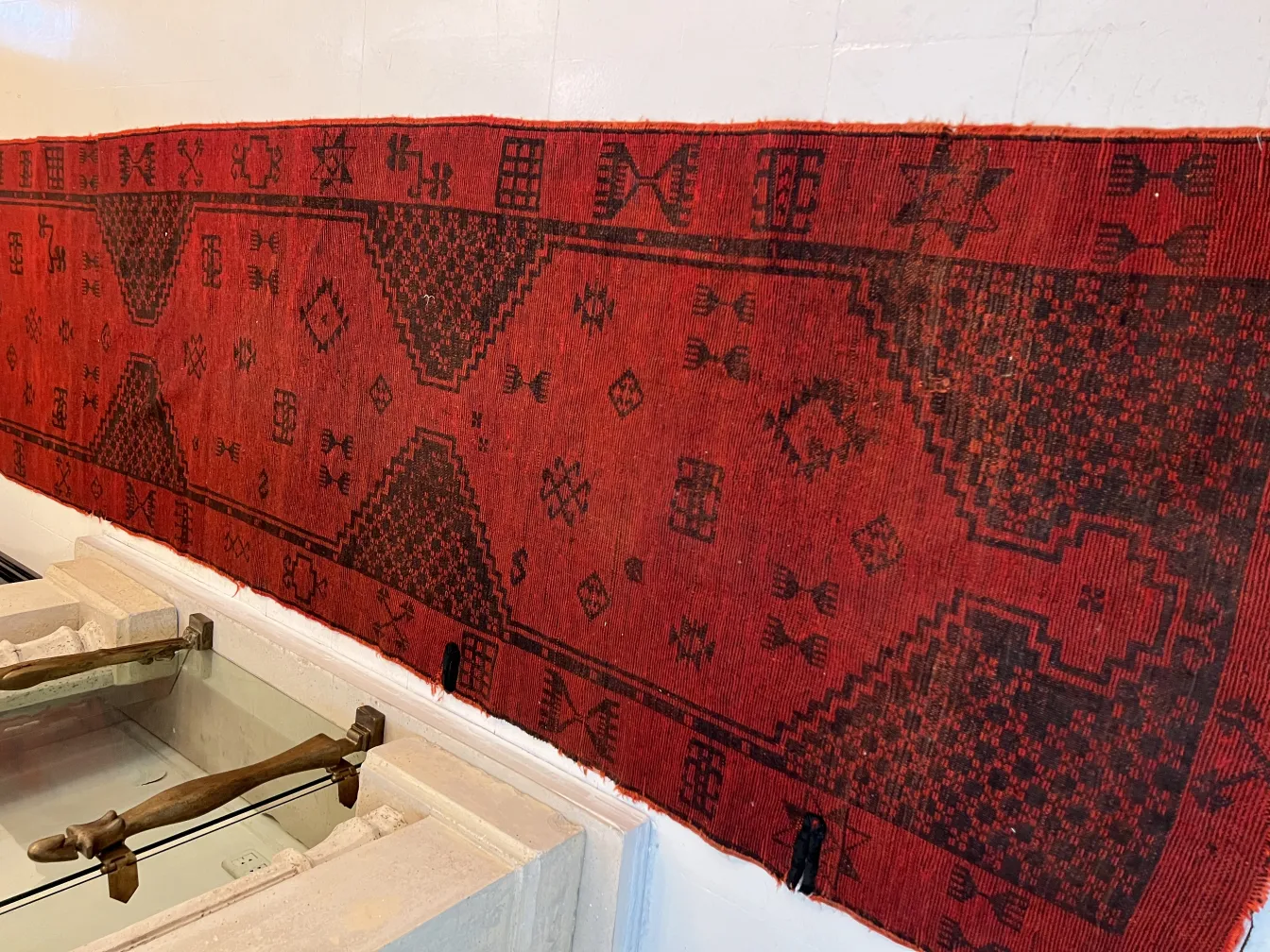 Tappeto antico rosso con motivi decorativi neri