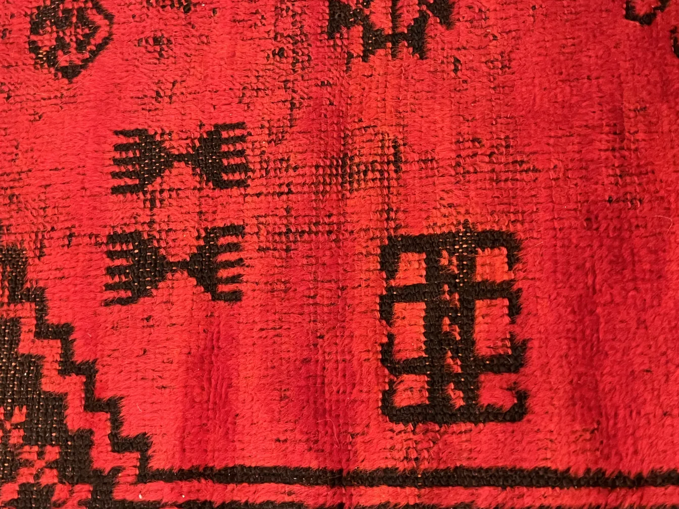 tappeto antico rosso con motivi neri, decorativo