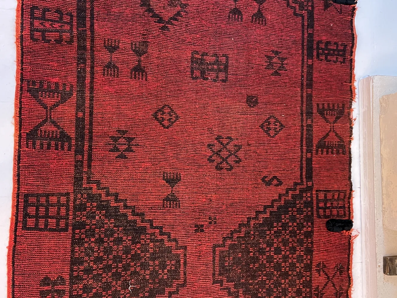 tappeto antico rosso con motivi geometrici distintivi