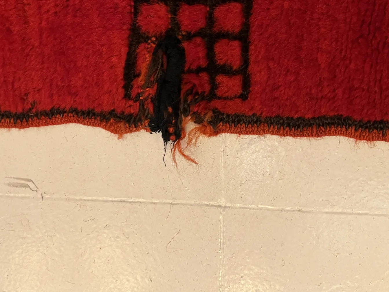 tappeto antico usurato rosso e nero, fili sciolti visibili