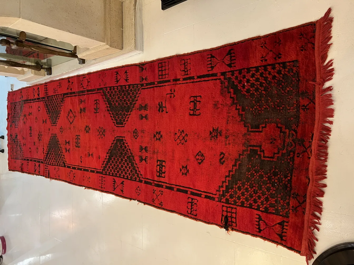 tappeto antico rosso con motivi decorativi in un ambiente elegante