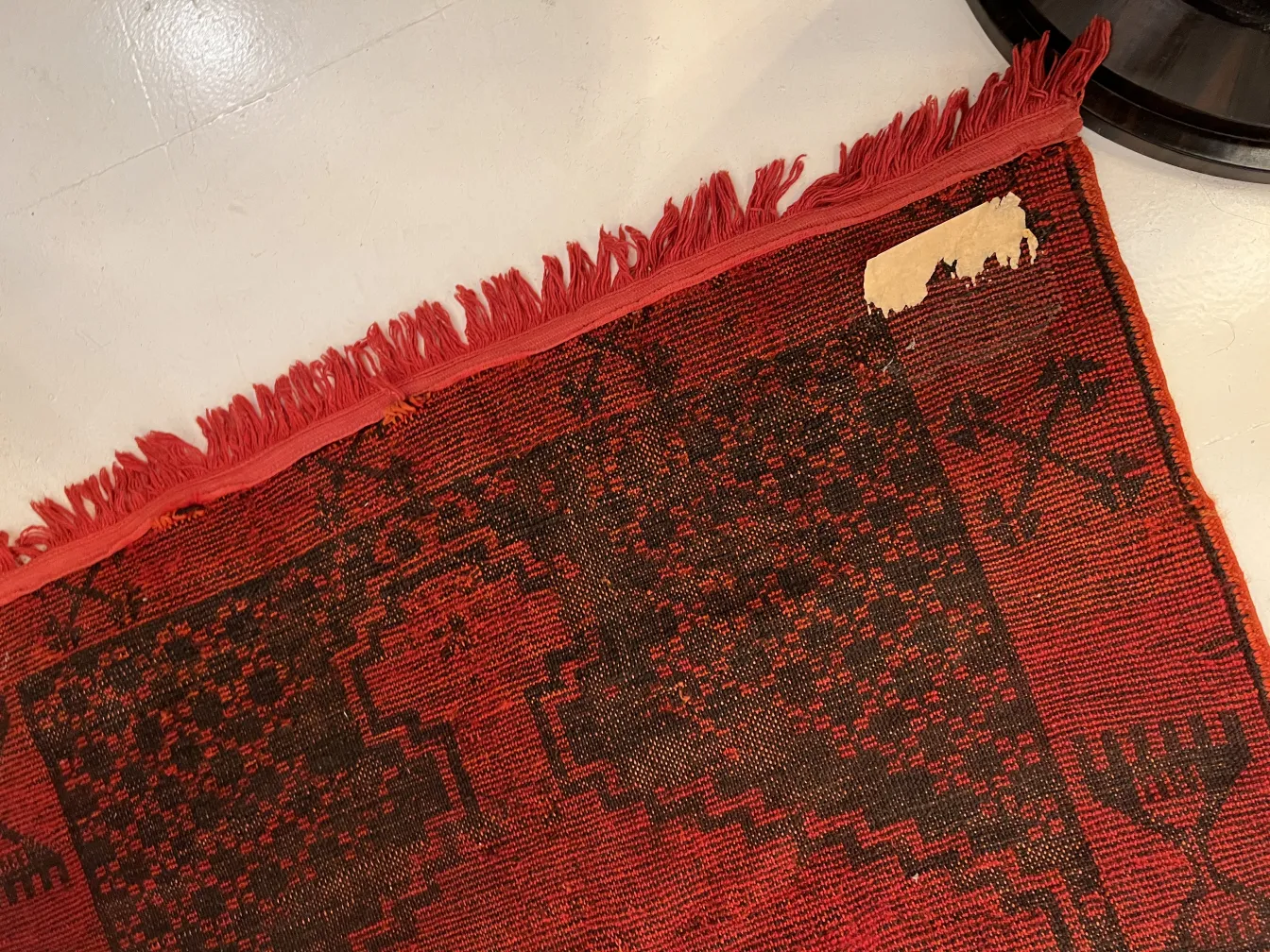 tappeto antico con frange, motivo rosso e nero