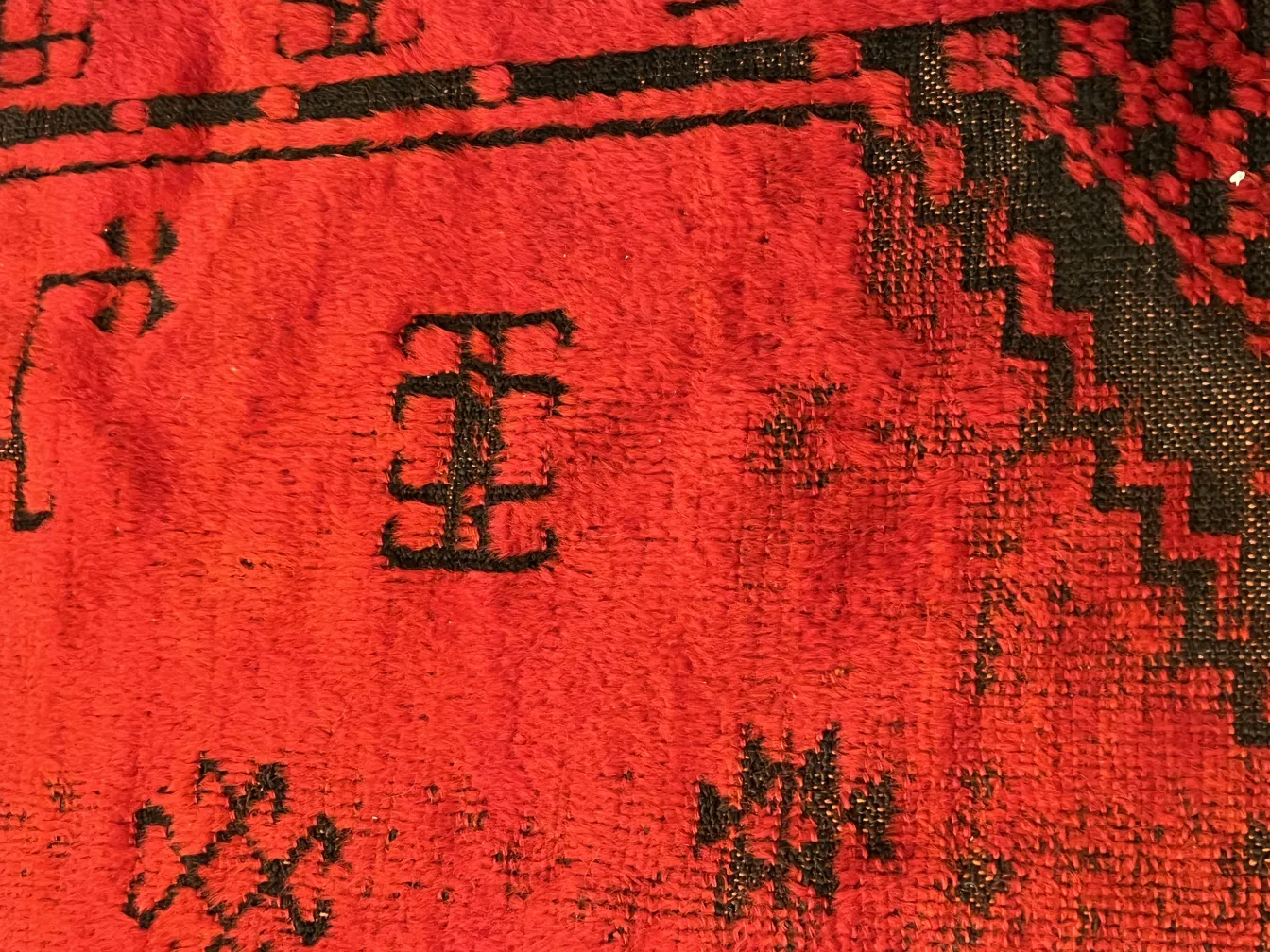 tappeto antico rosso e nero con motivi intricati