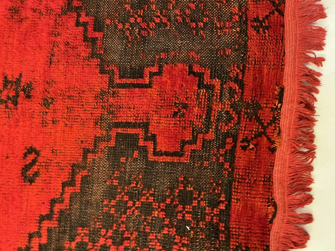 tappeto antico con design rosso e nero, ambiente accogliente