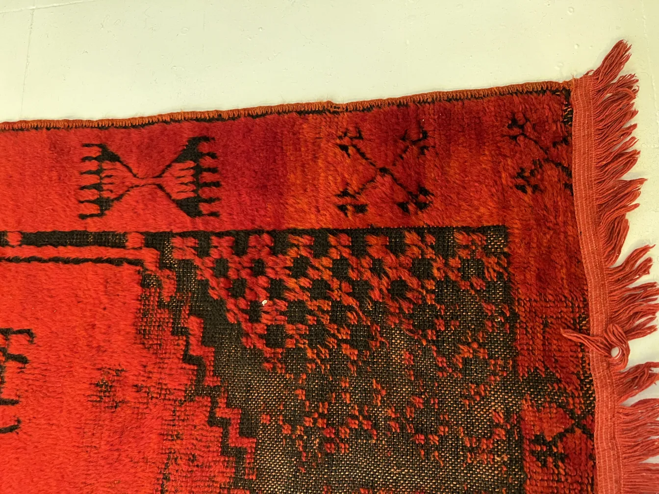 tappeto antico rosso con motivi intricati sul bordo