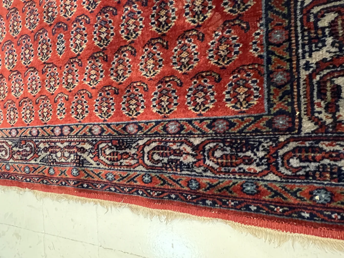tappeto antico rosso con motivi decorativi