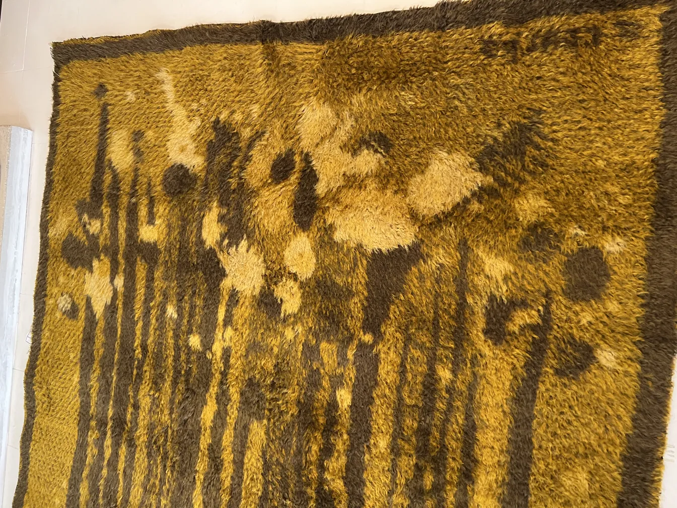 tappeto antico in tonalità giallo e marrone, decorazione floreale