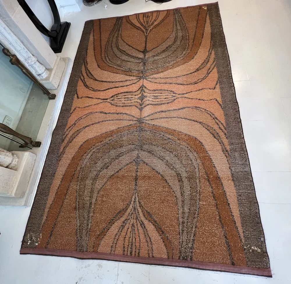 tappeto antico con design astratto in tonalità terrose