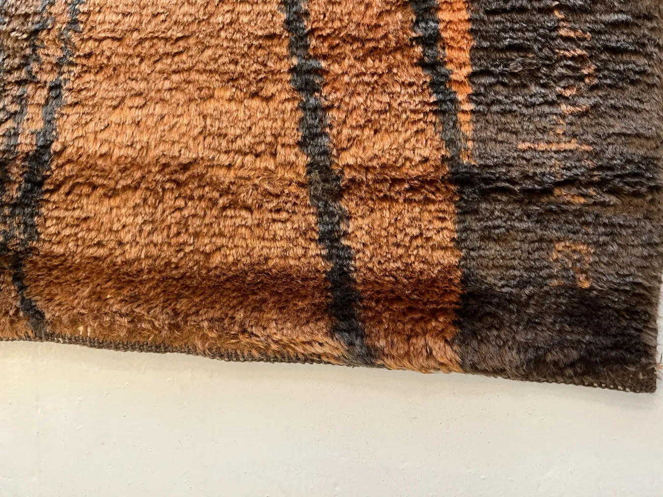 Tappeto antico con texture calde e motivo marrone.