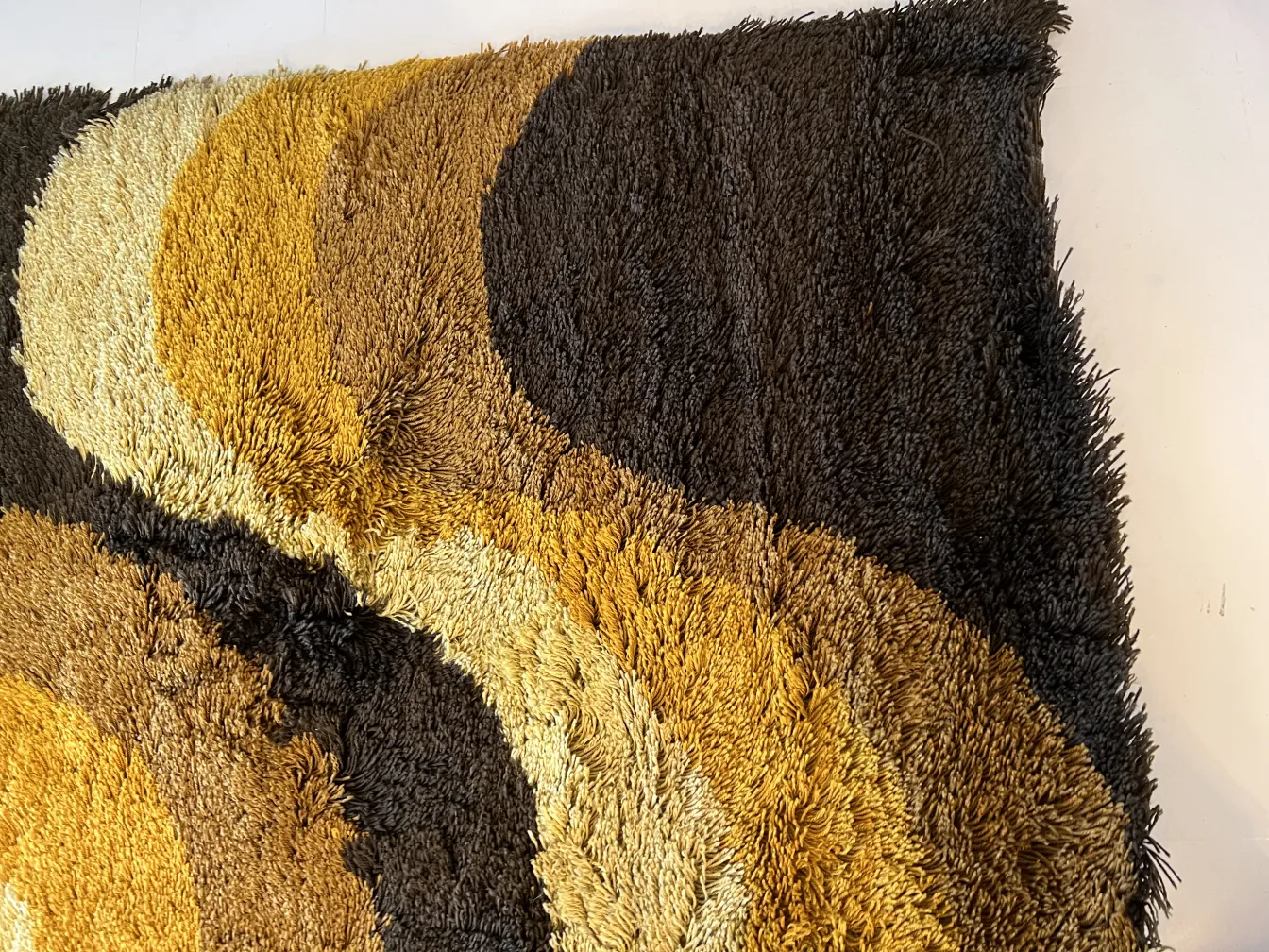 tappeto antico con colori marroni e gialli in design ondulato