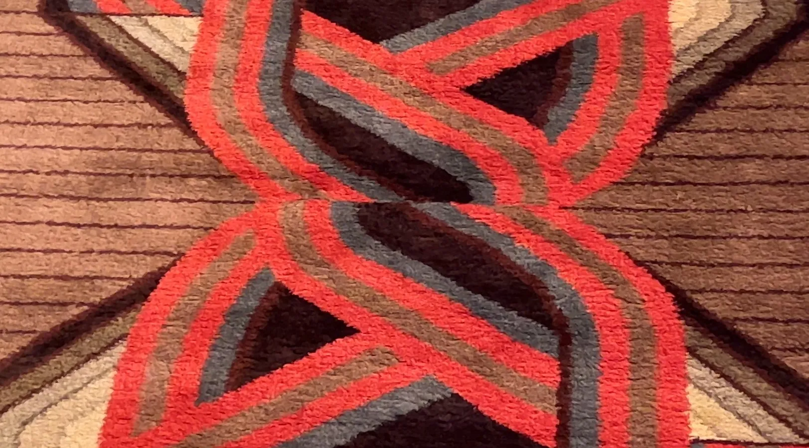 tappeto antico con toni caldi e motivi rossi e grigi