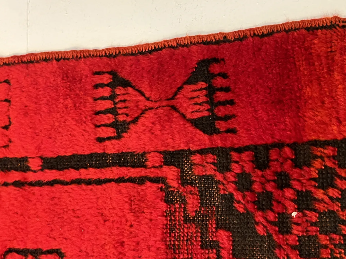 Tappeto antico rosso con disegni intricati