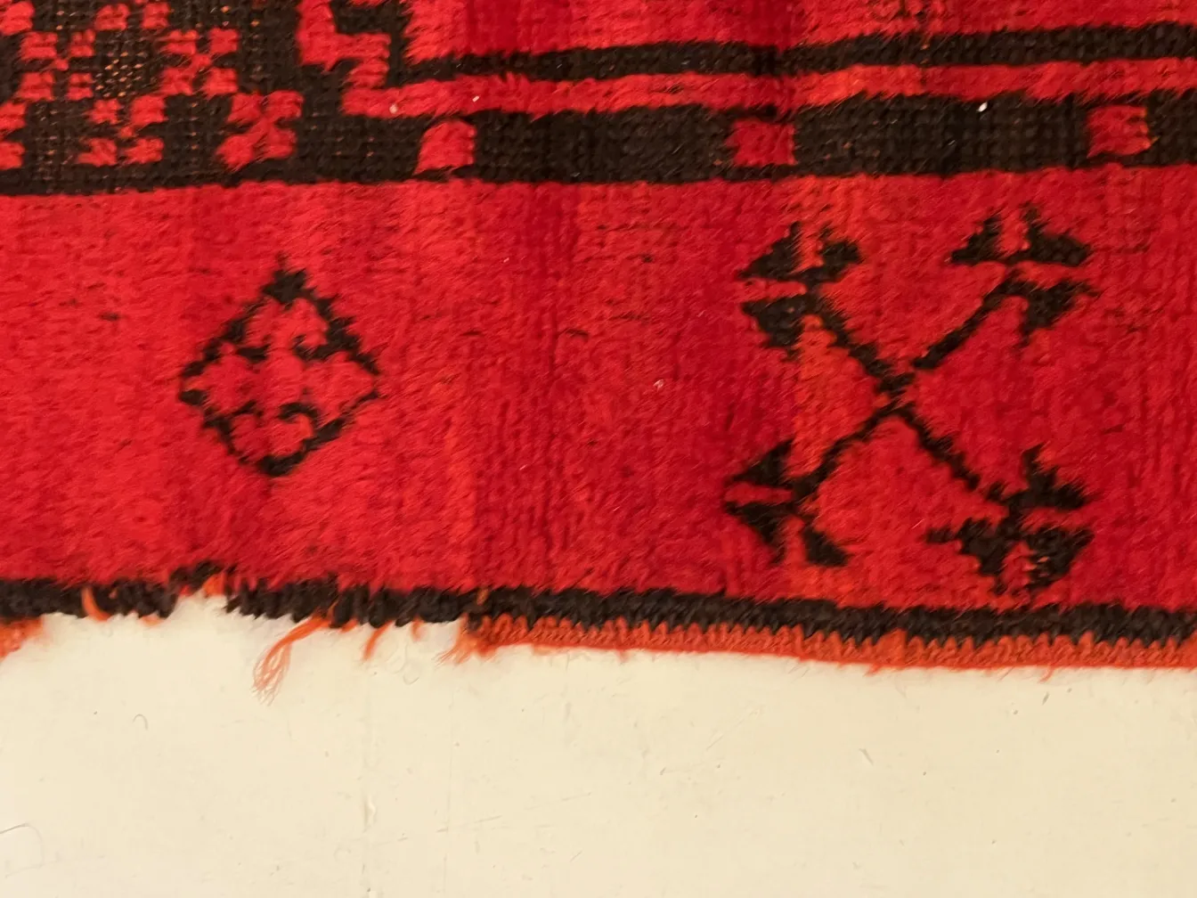 dettaglio di un tappeto antico rosso con motivi intricati