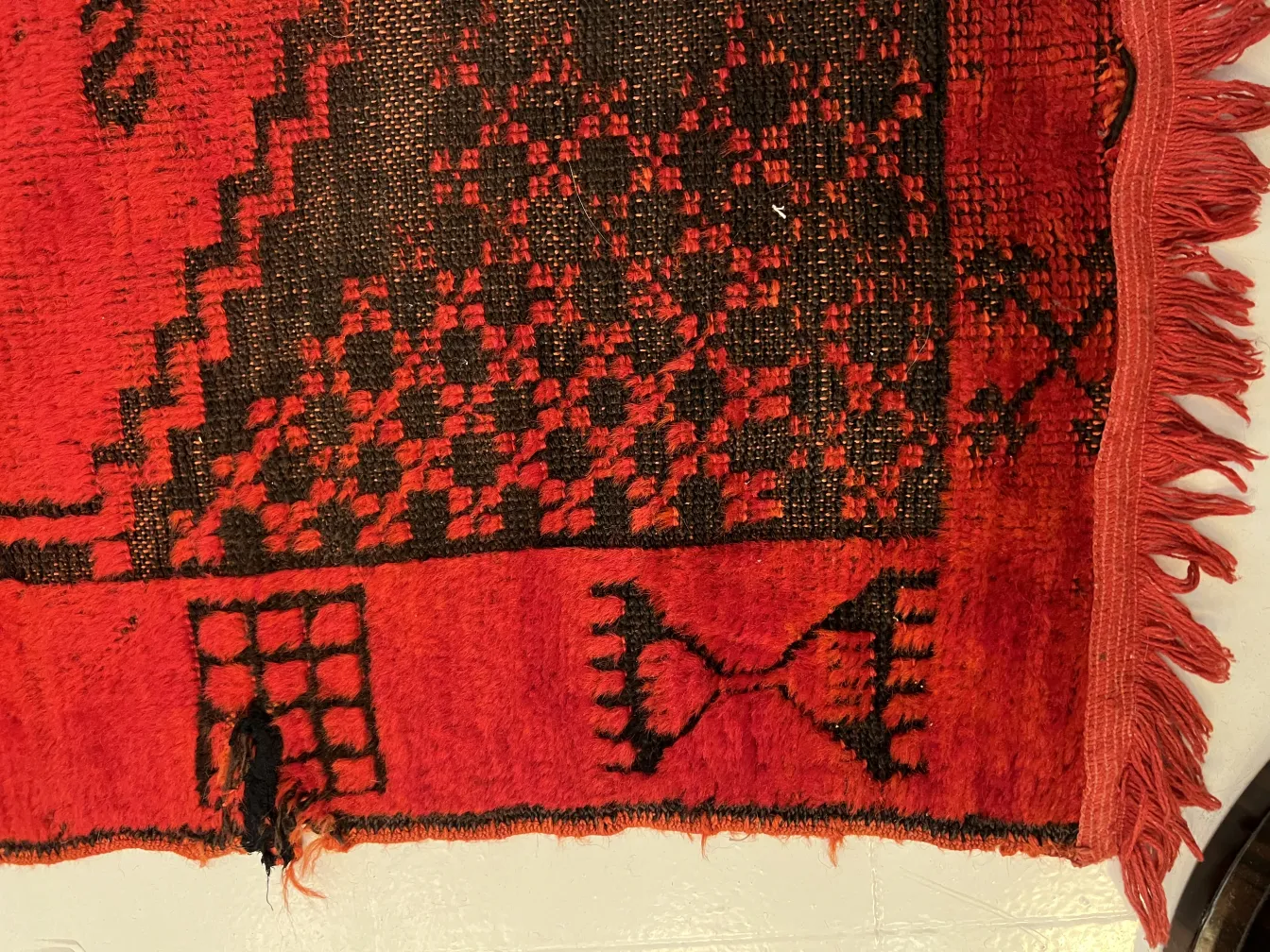 tappeto antico rosso e nero con motivi geometrici