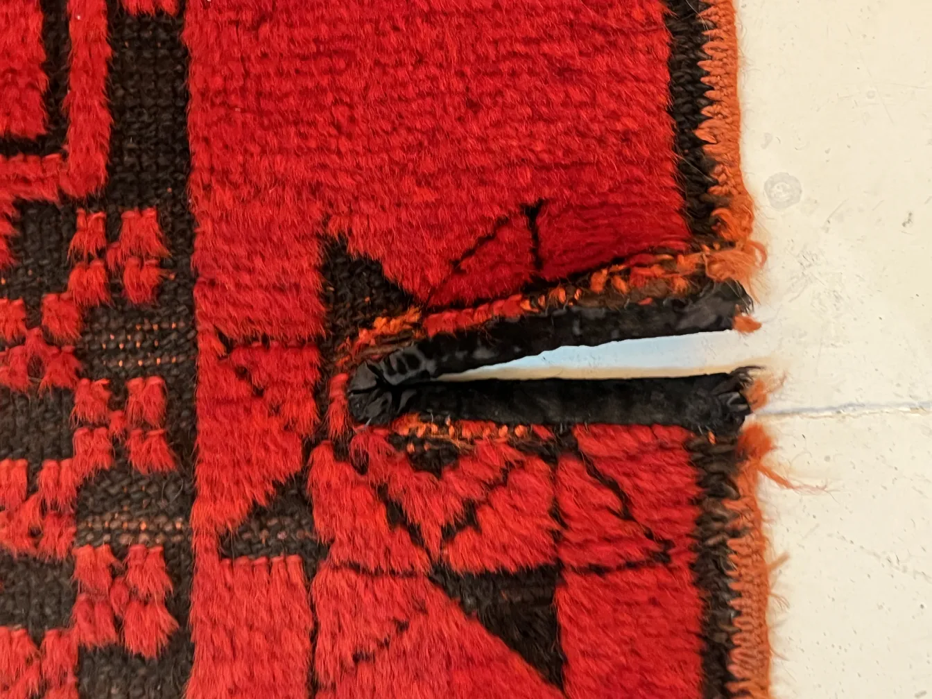 tappeto antico decorativo in tonalità rosse con dettagli neri