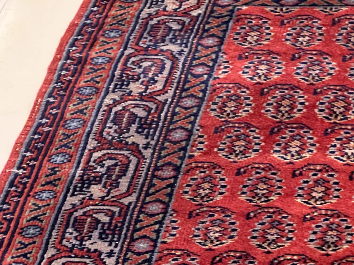 tappeto antico rosso con motivi intricati