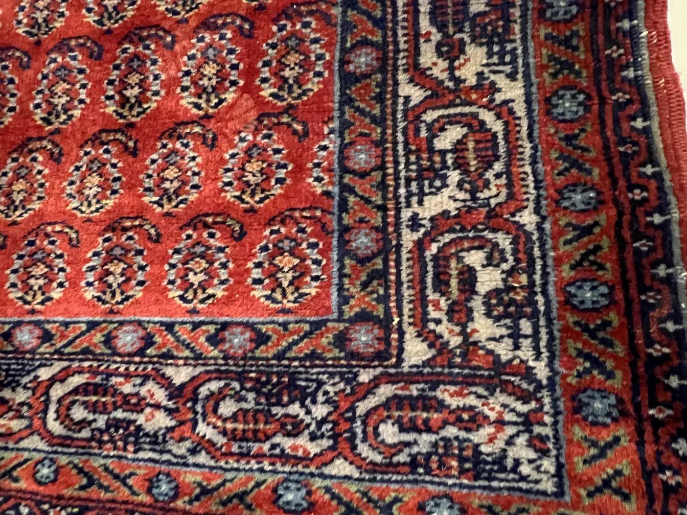 tappeto antico con motivo paisley rosso e blu in un ambiente classico