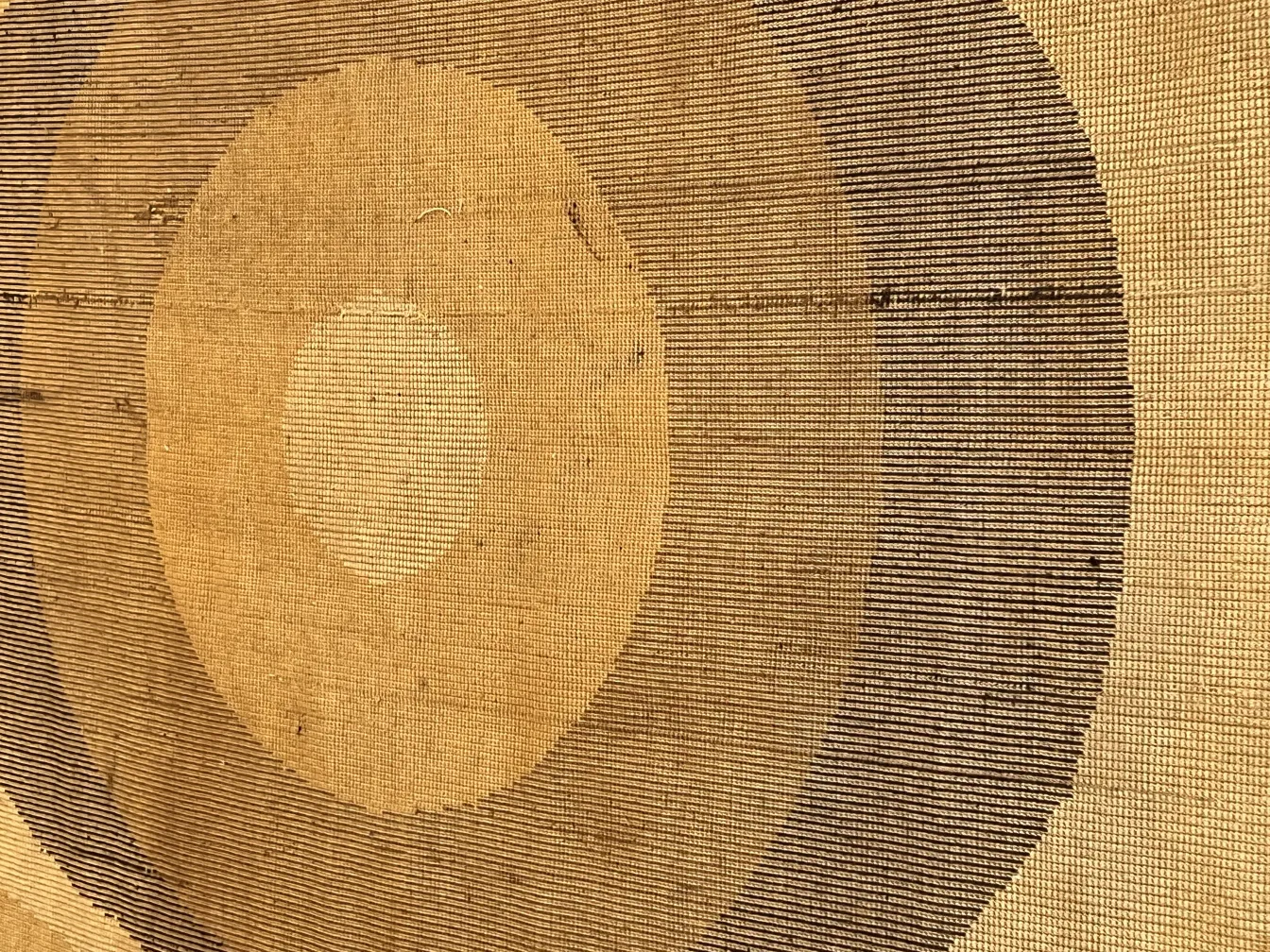 tappeto antico con motivo circolare in tonalità beige e marrone.