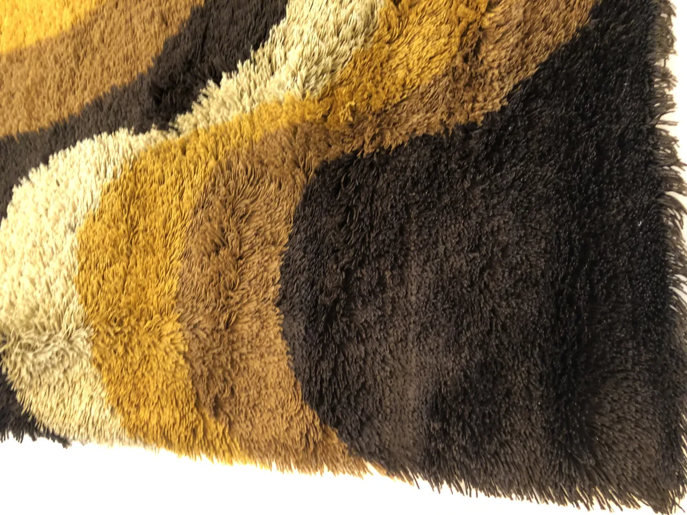 Tappeto antico con colori marrone, beige e nero in design circolare.