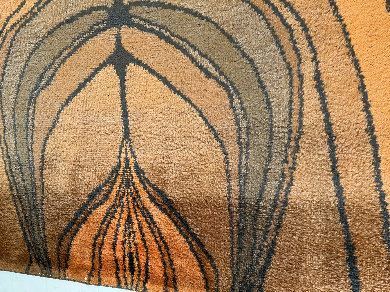 tappeto antico con design astratto in tonalità terrose